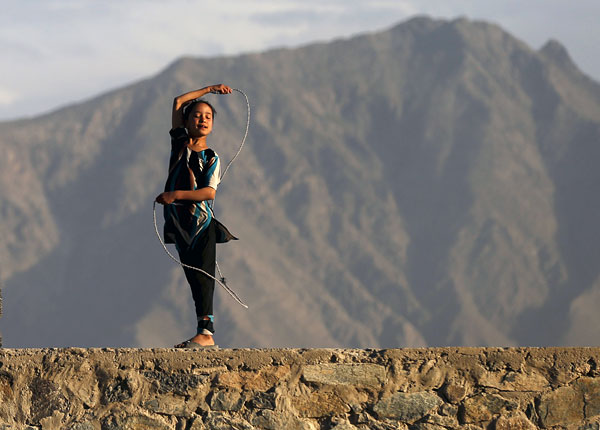 Афганская девочка играет с веревкой на вершине холма в Кабуле. Афганистан.