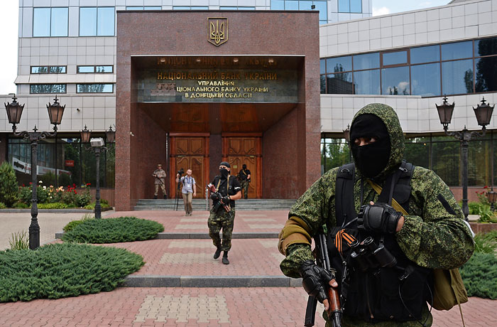 Вооруженные люди у входа в здание управления Национального банка Украины в Донецке.