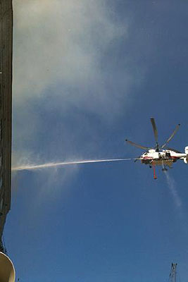 Пожарный вертолет тушит огонь на крыше здания НПО "Алмаз"