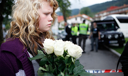 Местные жители возлагают цветы в память о погибших в результате взрыва у здания норвежского правительства и стрельбы в молодежном лагере на острове Утойа.