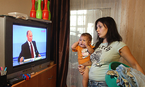 Домохозяйка с ребенком во время трансляции телепрограммы "Разговор с Владимиром Путиным. Продолжение".