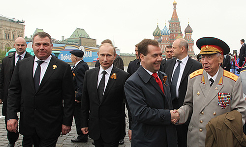 Исполняющий обязанности министра обороны РФ Анатолий Сердюков, президент РФ Владимир Путин и председатель правительства России Дмитрий Медведев во время военного Парада Победы на Красной площади.