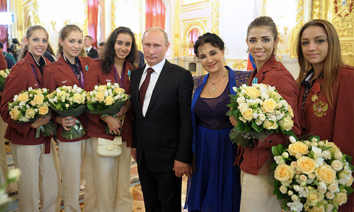 Владимир Путин, российские гимнастки Анастасия Близнюк, Ульяна Донскова, Анастасия Назаренко (слева направо), Евгения Канаева, Алина Макаренко и главный тренер сборной России по художественной гимнастике Ирина Винер (справа налево) на торжественной церемонии вручения государственных наград в Александровском зале Большого Кремлевского дворца.