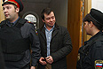 Активист "Левого фронта" Константин Лебедев (в центре), обвиняемый в подготовке массовых беспорядков, перед началом заседания о мере пресечения в Басманном суде.