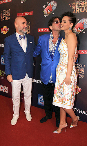 Совладелец "Русской медиа-группы" Сергей Кожевников (слева) с супругой Екатериной и певец Григорий Лепс (справа) на церемонии вручения русской музыкальной премии телеканала RU.TV 2013.