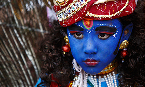 Мальчик, одетый богом Кришной, во время празднования Gaijatra, или "праздника коров", в Непале.