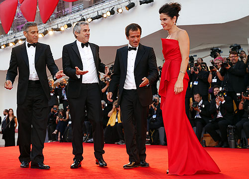 Актер Джордж Клуни, режиссер Альфонсо Куарон и продюсер Дэвид Хейман приветствуют актрису Сандру Буллок.
