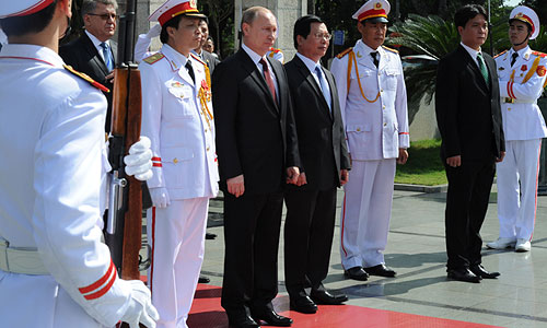 Президент России Владимир Путин (четвертый слева) и начальник мемориального комплекса Нгуен ван Кыонг (четвертый справа) на церемонии возложения венков к Мемориалу павшим героям в Ханое.