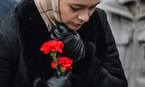 Женщина в международном аэропорту "Казань" несет цветы в память о погибших в авиакатастрофе самолета Boeing 737 авиакомпании "Татарстан", разбившегося при посадке.