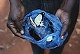 Охотник на бабочек Дидие Мимиката показывает свой улов в деревне Ботимбо (Центральная Африканская республика). Свою добычу охотники на бабочек продают художникам, которые собирают из крыльев мозаики - традиционные поделки этого региона.