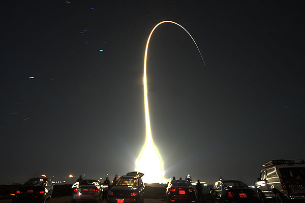 Люди наблюдают за запуском ракеты Atlas V с коммерческим грузом Национального управления военно-космической разведки США на военной базе Ванденберг (штат Калифорния) 5 декабря.