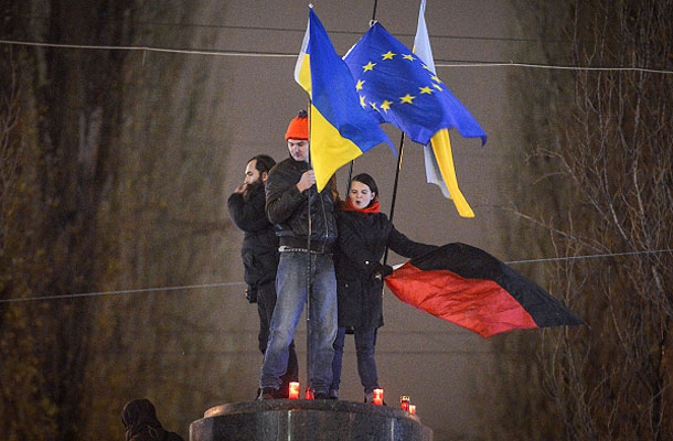 Участники акции в поддержку евроинтеграции Украины стоят на постаменте памятника Ленину, снесенного ими на Бессарабской площади в центре Киева.