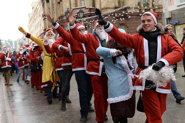 Участники костюмированного шествия Дедов Морозов в центре Москвы.