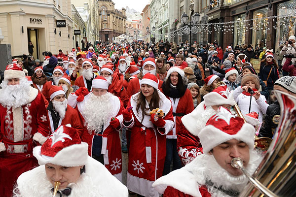 Участники костюмированного шествия Дедов Морозов в центре Москвы.