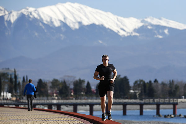 Мужчина на пробежке по набережной.