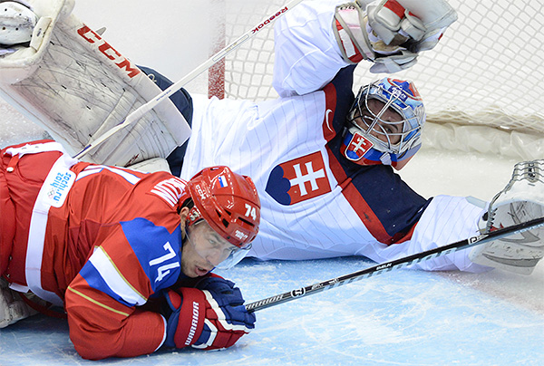 Слева: Алексей Емелин (Россия) в матче группового этапа между сборными командами России и Словакии на соревнованиях по хоккею среди мужчин на XXII зимних Олимпийских играх в Сочи.