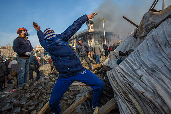 Самооборона Майдана бросает камни в сторону милиции.