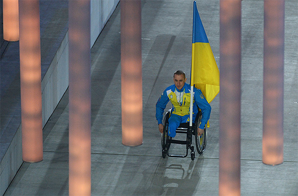 Знаменосец сборной Украины Михайло Ткаченко во время парада атлетов и членов национальных делегаций на церемонии открытия XI зимних Паралимпийских игр в Сочи.