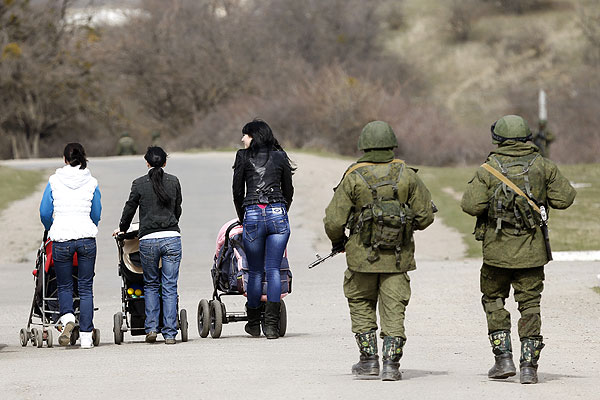 Женщины с колясками на прогулке. Позади идут военные.
