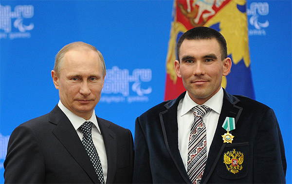 Президент России Владимир Путин и паралимпийский чемпион в биатлоне и лыжных гонках Кирилл Михайлов во время церемонии вручения государственных наград Российской Федерации в Сочи.