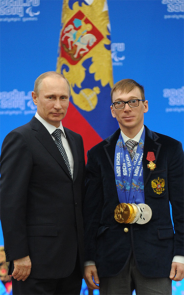 Владимир Путин и двукратный паралимпийский чемпион в биатлоне Николай Полухин во время церемонии вручения государственных наград Российской Федерации в Сочи.