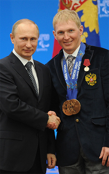 Президент России Владимир Путин (слева) и двукратный бронзовый призер паралипийских игр в биатлоне и лыжных гонках Александр Давидович во время церемонии вручения государственных наград Российской Федерации в Сочи.