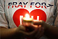 Горящая свеча во время молитвы за пассажиров малайзийского Boeing-777.