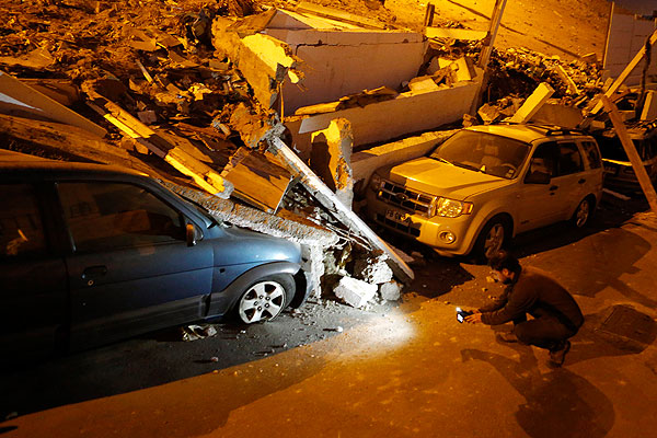 Мужчина фиксирует на камеру последствия землетрясения в чилийском городе Икике.