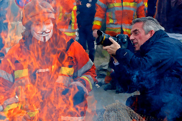Фотограф снимает бельгийского пожарного в маске Гая Фокса во время забастовки пожарных.