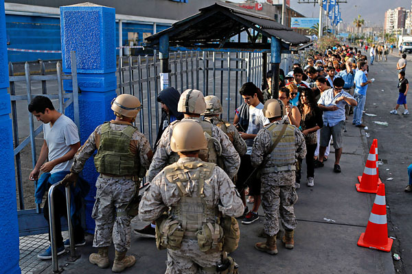 Солдаты контролируют доступ в супермаркет в городе Икике.