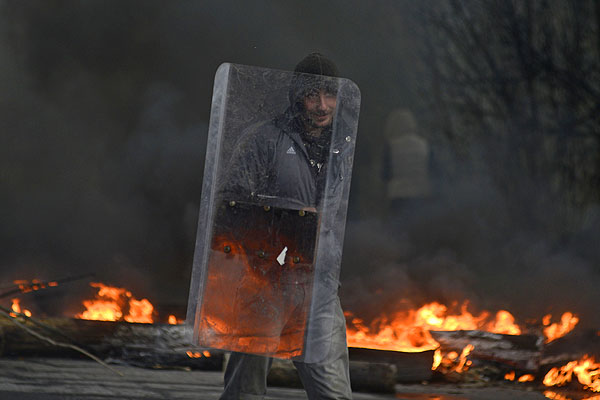 Мужчина со щитом в дыму от горящих автомобильных покрышек. Центр Славянска. Воскресенье, 13 апреля.