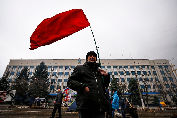 Житель Луганска с советским флагом перед зданием СБУ.