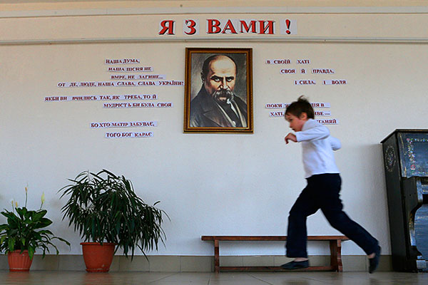 Ученик симферопольской школы бежит по коридору. На стене портрет украинского поэта Тараса Шевченко.