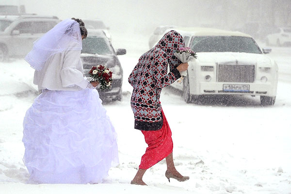 Невеста идет по улице во время сильного снегопада в Челябинске.