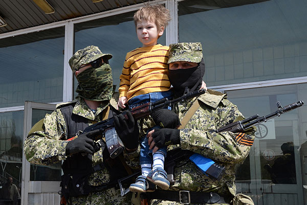 Ополченцы фотографируются с ребенком у захваченного здания городского совета Константиновки Донецкой области.