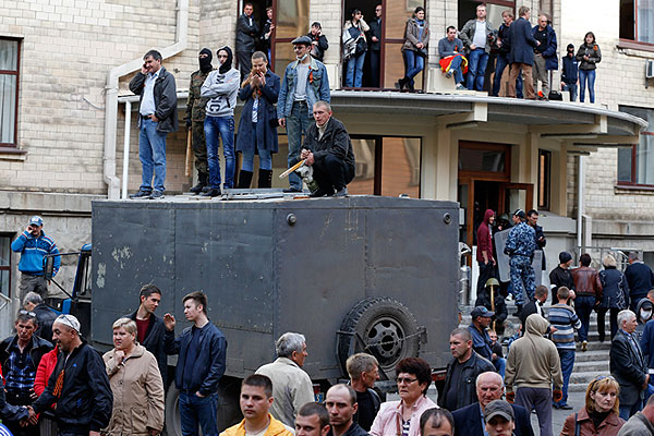 Возле здания Луганской обладминистрации остаются по крайней мере две тысячи митингующих. Они держат флаги России, флаги "Луганской гвардии", у многих в руках палки и дубинки.