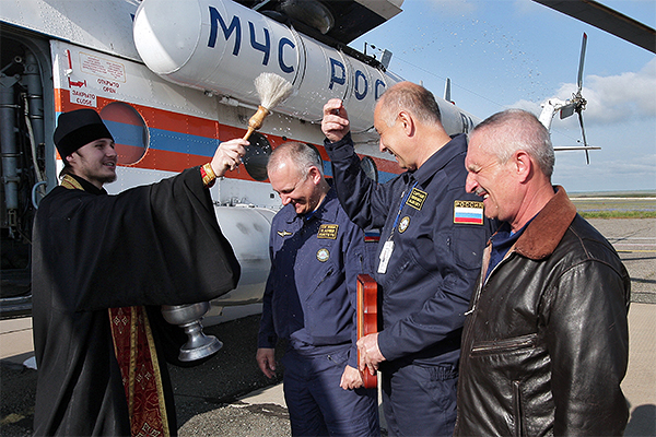 Священник Симферопольской и Крымской епархии Московского патриархата отец Василий освящает командира вертолета МИ-8 Алексея Диденко (второй справа) в Симферополе.