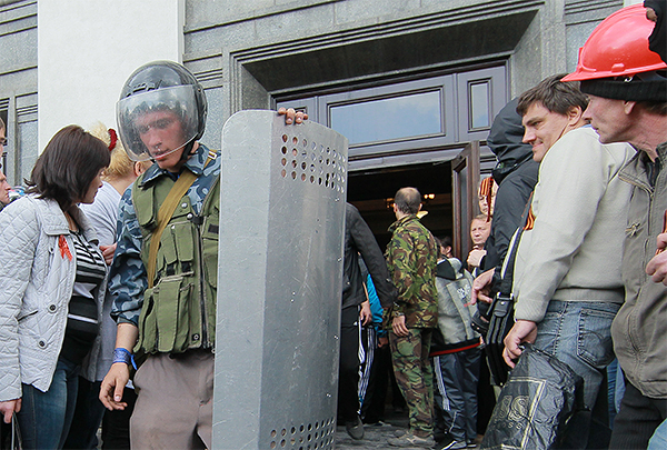 Представители самообороны выходят из здания областной администрации в Луганске, взятого под контроль сторонниками федерализации.