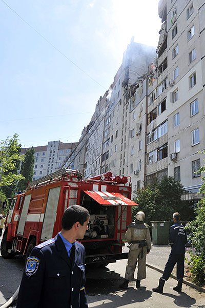 Пожарные осматривают поврежденное здание.