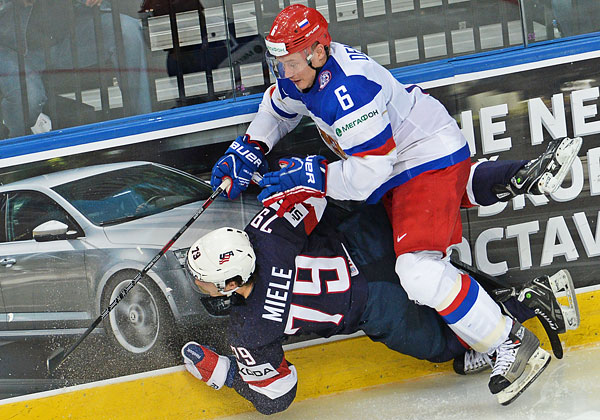 Игрок сборной США Энди Мил (слева) и игрок сборной России Денис Денисов в матче группового раунда Чемпионата мира по хоккею 2014 между сборными командами России и США.