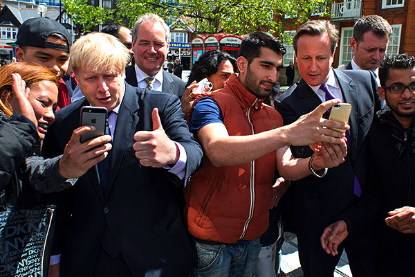 Селфи-мания продолжается. Мэр Лондона Борис Джонсон и премьер-министр Великобритании Дэвид Кэмерон фотографируются с жителями Хэрроу. Хэрроу - один из 32 лондонских боро, часть исторического графства Мидлсекс. Расположен на северо-западе Большого Лондона.