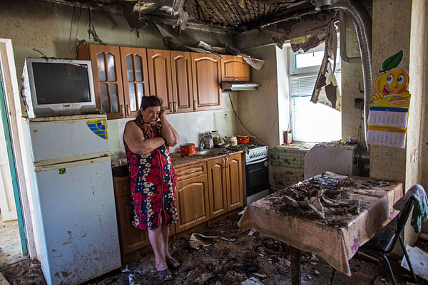 Женщина в своем доме, пострадавшем в результате ночного артобстрела со стороны украинских военных на окраине Славянска.
