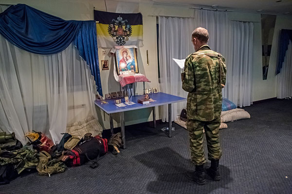 Боец народного ополчения молится перед ночным боем на передовой позиции возле Славянска.