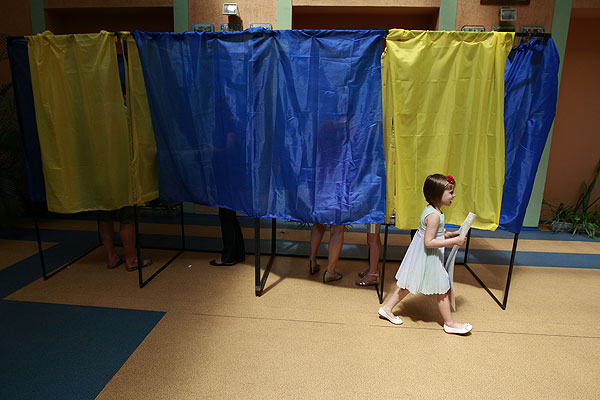 Девочка несет бюллетени на одном из избирательных участков.
