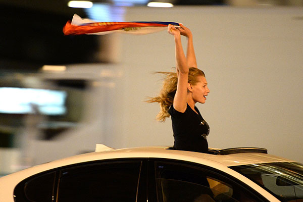 Девушка с российским флагом радуется итогу матча с Финляндией.