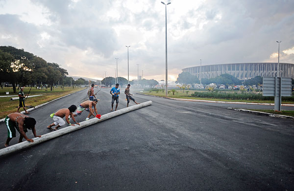 Группа демонстрантов пытается перекрыть дорогу, ведущую к Национальному стадиону Бразилии.
