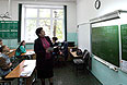 Преподаватель смотрит на часы перед началом сдачи единого государственного экзамена по русскому языку в средней образовательной школе №28 города Владивостока.