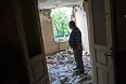 Мужчина в комнате своего дома, разрушенного в результате попадания снаряда во время обстрела украинскими силовиками, в поселке Червоный Молочар возле Славянска.