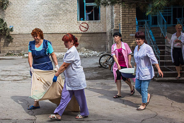 Работники больницы убирают последствия разрушений от попадания снаряда в здание больницы в Славянске во время обстрела украинскими силовиками жилых районов города.
