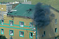 Попадание снаряда из гранатомета в здание воинской части погранслужбы Украины на окраине Луганска во время боев ополченцев с украинскими погранвойсками.